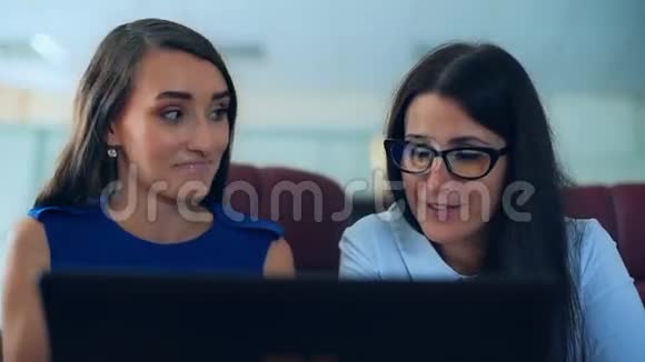 两个女商人和笔记本电脑一起讨论和工作视频的预览图