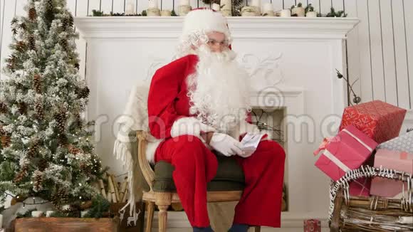 嘲笑圣诞老人坐在圣诞车间的椅子上视频的预览图