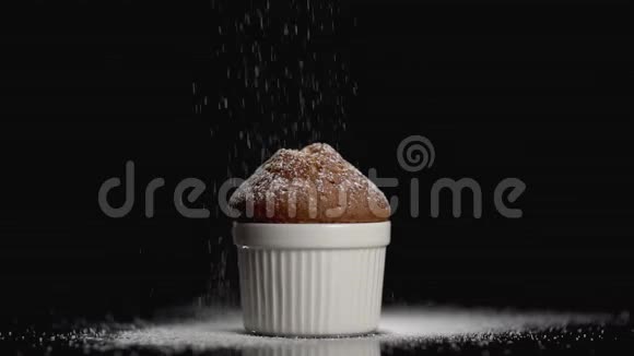 在黑色背景上洒上加糖粉的松饼蛋糕视频的预览图
