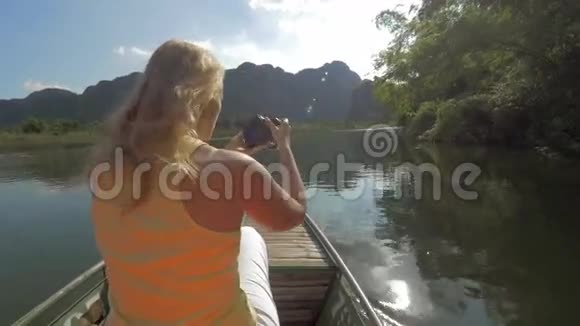 在船上用照相机看金发女人游览哈龙湾船岛游览越南河内视频的预览图