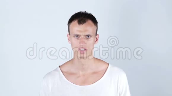 一个穿着白色T恤白色背景的头晕目眩的年轻人视频的预览图