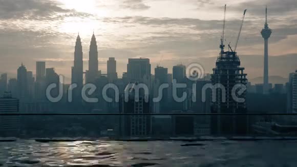 摩天大楼屋顶上的游泳池与日出建筑城市景观的时间间隔视图马来西亚吉隆坡视频的预览图