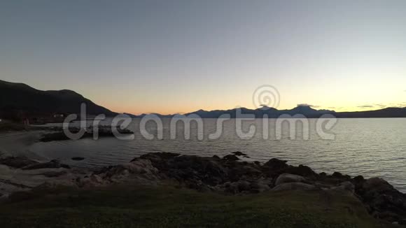 五颜六色的日落山脉与新的雪和平静的反射峡湾在右边视频的预览图