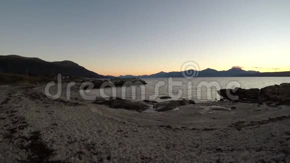 五颜六色的日落山脉与新的雪和平静的反射峡湾在右边视频的预览图