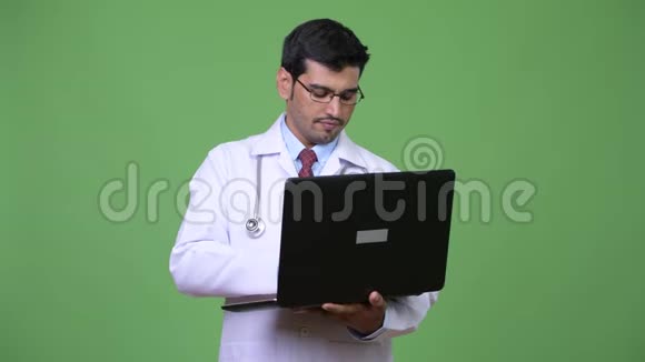 年轻英俊的波斯医生用笔记本电脑视频的预览图