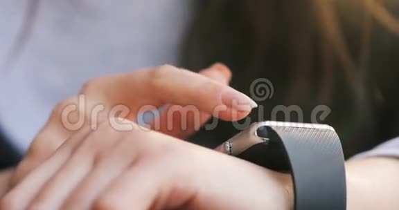 女性在可穿戴智能手表电脑设备上做手势智能手表关闭4k视频的预览图