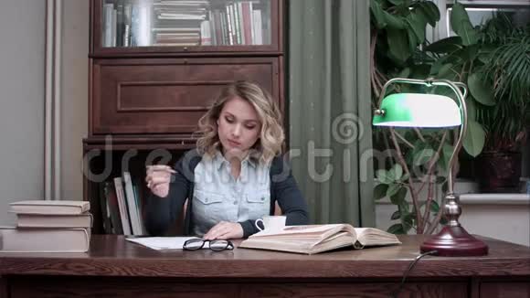 忙着工作的年轻女人做笔记喝了咖啡后呛着视频的预览图