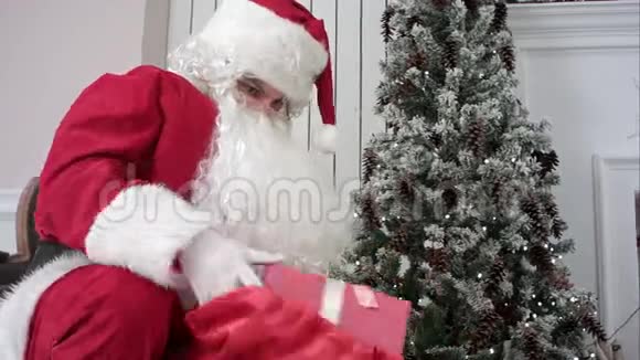 圣诞老人打开口袋把礼物放在圣诞树下视频的预览图