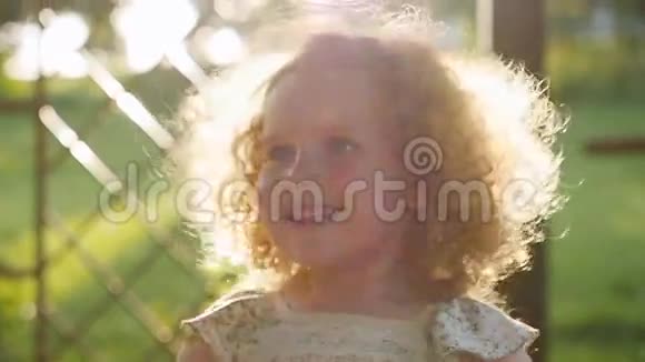夕阳照在一个小女孩的卷发上视频的预览图