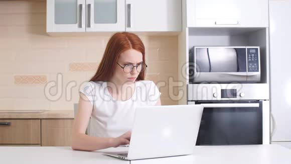 时髦的红发女孩在家里工作视频的预览图