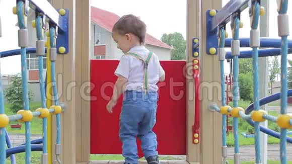小男孩在操场上玩耍坐下来站起来视频的预览图