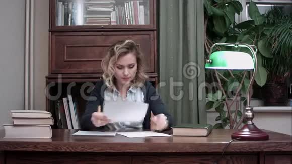 年轻女子翻阅文件做笔记视频的预览图