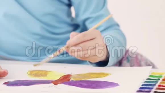 女孩手中的水彩画蝴蝶放在房间的桌子上合上视频的预览图