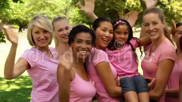 公园里穿着粉色衣服的快乐女人在对着镜头挥手视频的预览图