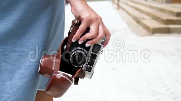 慢镜头视频年轻的旅游女孩走在街上拿着老式的摄像机视频的预览图