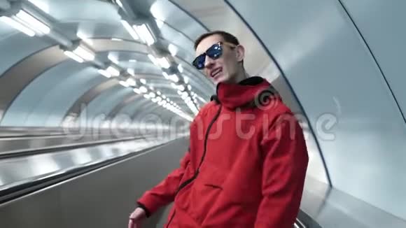 穿着红色夹克和太阳镜的年轻男性在旅行者身上咆哮视频的预览图