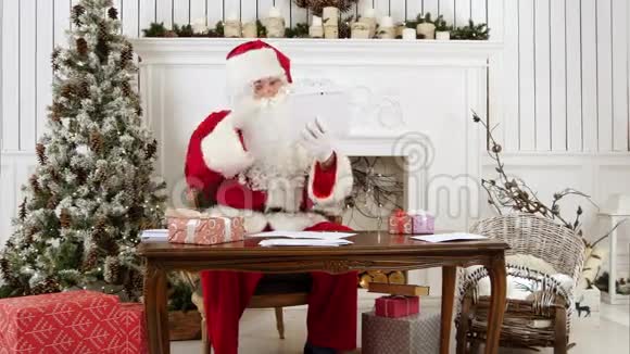 圣诞老人兴高采烈地通过平板电脑交谈视频的预览图