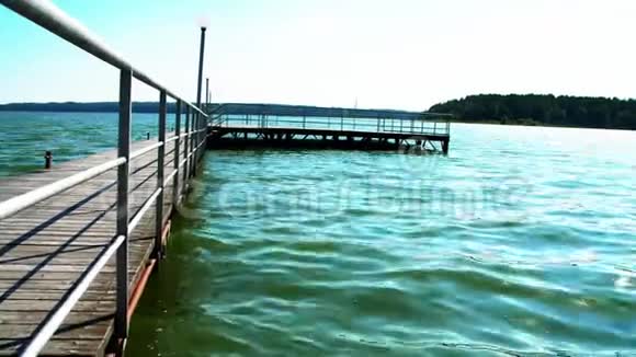 一个夏天相机沿着木制美丽的码头和附加的船只移动视频的预览图