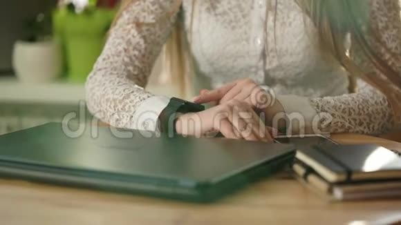 商务女士手谁使用智能手表笔记本电脑和智能手机工作视频的预览图