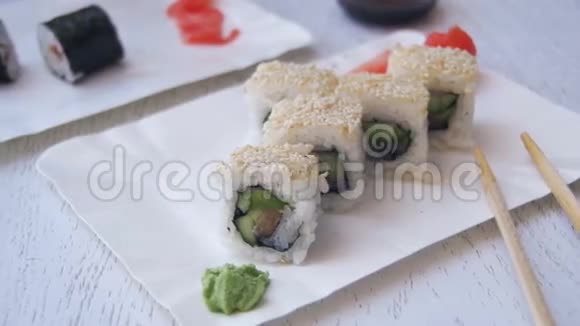 筷子从盘子里取出寿司卷在日本餐馆里蘸酱油慢动作视频的预览图