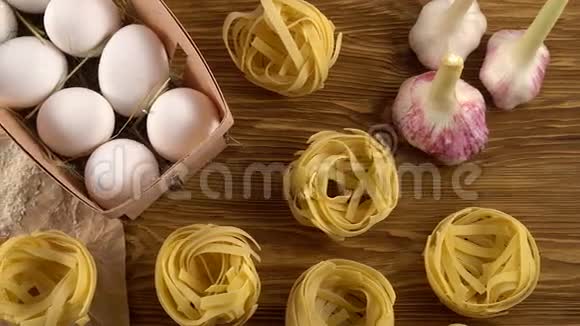 木制背景的意大利面鸡蛋油番茄酱大蒜和面粉视频的预览图