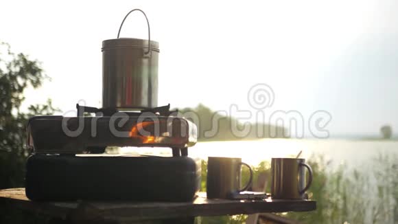 从桌子上拿一杯热咖啡放在湖底上面放着朝阳的光芒视频的预览图