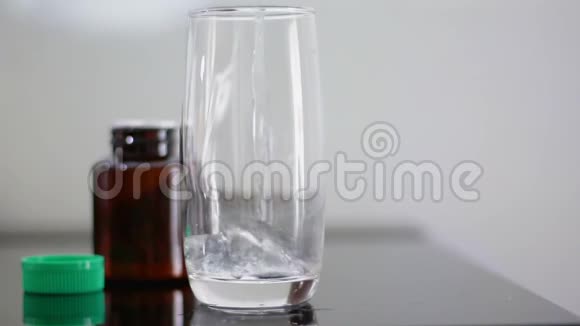 特写镜头把水倒入透明的杯子里吃药视频的预览图