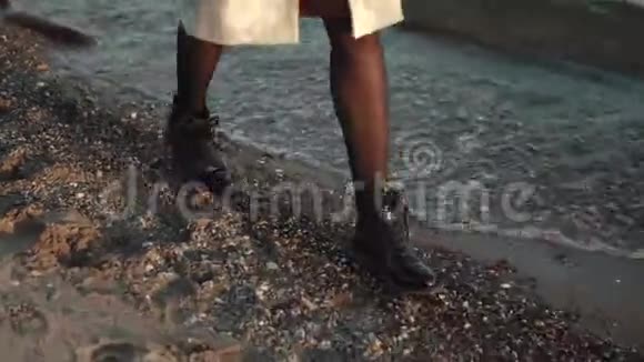 女性腿部特写这个女孩正沿着海边的沙滩散步视频的预览图