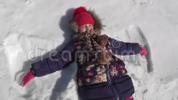 冬天的天气女孩在雪地里做蝴蝶视频的预览图