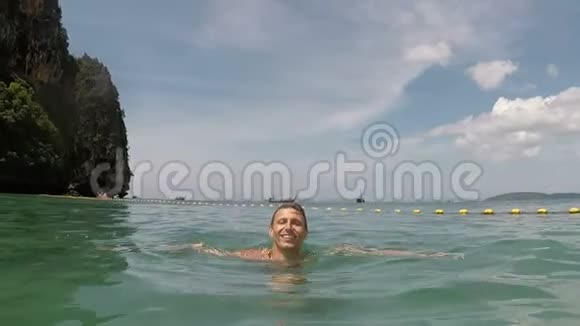 在美丽的海滩上快乐的人在海水中游泳动作镜头视频的预览图