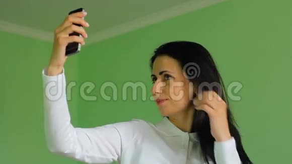 漂亮的深色头发的女性在拍自拍高清镜头视频的预览图