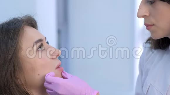 医生美容师在女性嘴唇上进行注射使其体积和矫正形状视频的预览图