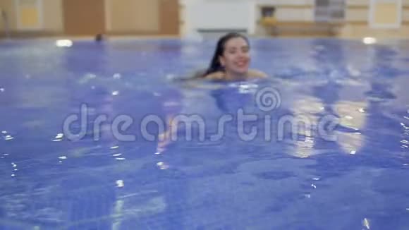 红唇迷人的女士在游泳池里游泳视频的预览图