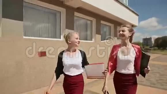 两个美丽而快乐的女孩是大学笔记的学生前景视频的预览图