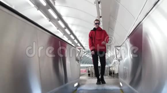 穿着红色夹克和太阳镜的有魅力的男性在旅行者身上怒斥视频的预览图