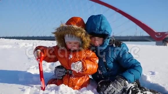 阳光明媚的冬日快乐的孩子们在公园里玩耍雪的冬季景观户外视频的预览图