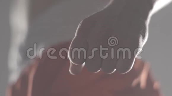 一个穿着运动服的年轻拳击手用一种威胁的手势紧握着他的拳头拳击手紧握拳头视频的预览图