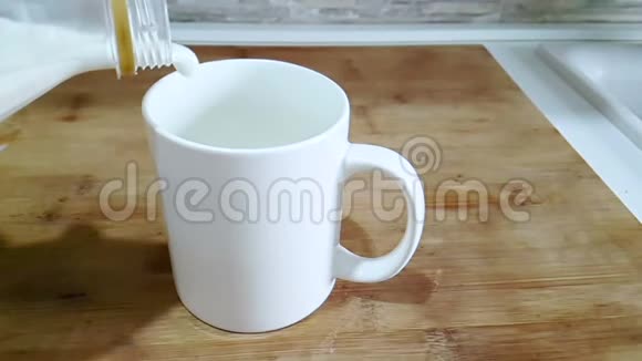 在厨房背景下新鲜的白牛奶倒入酒杯中拍摄时动作缓慢饮食健康营养健康视频的预览图