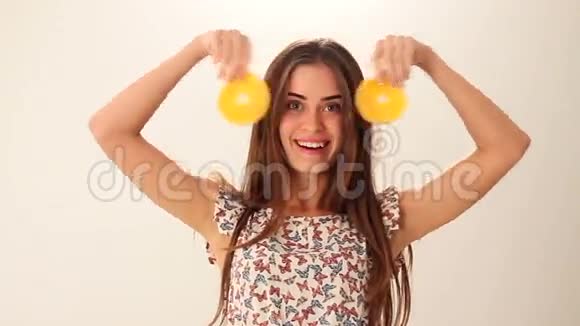 女人拿着两块橘子视频的预览图