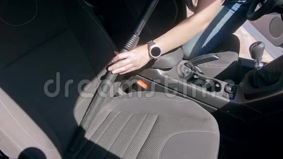 年轻女子用吸尘器清洁乘客座椅的慢速镜头视频的预览图