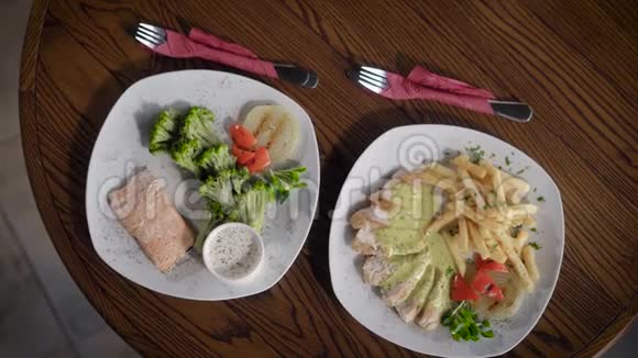 从餐厅看到的盘子和食物的顶部它们站在一张木桌上盘子上放着一条鱼视频的预览图