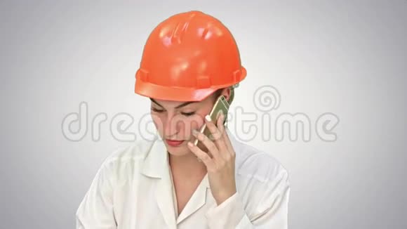 愤怒的女建筑工人在一个硬帽喊叫在智能手机上谈论白色背景视频的预览图