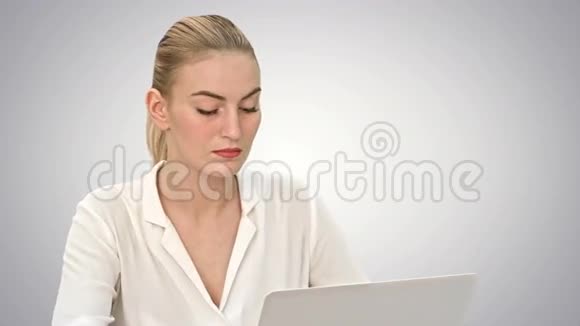 年轻的金发女商人在白色背景下使用笔记本电脑视频的预览图