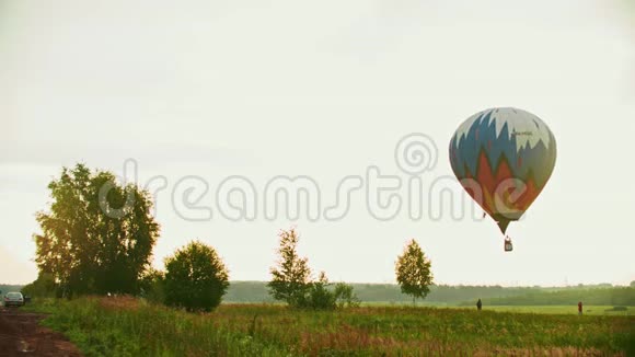 一个巨大的彩色气球利用热技术飞越草地视频的预览图