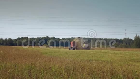 收割机用拖拉机在田里收草视频的预览图
