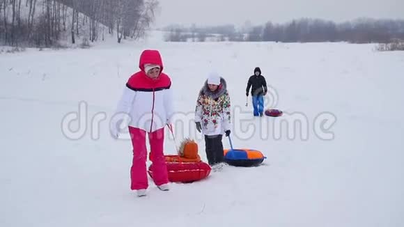一家人带着雪筒来到雪山慢动作冬季雪景积极休息运动视频的预览图