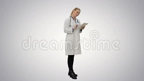 漂亮的女性医生用听诊器很高兴在白色背景下使用数字平板电脑取得了很好的效果视频的预览图