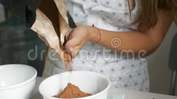 女人把可可加到碗里煮回家做的巧克力视频的预览图