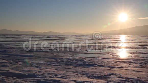 日落时分人们在贝加尔湖的冰上滑冰视频的预览图