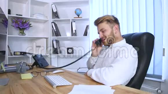 在办公室工作的快乐男人接电话视频的预览图